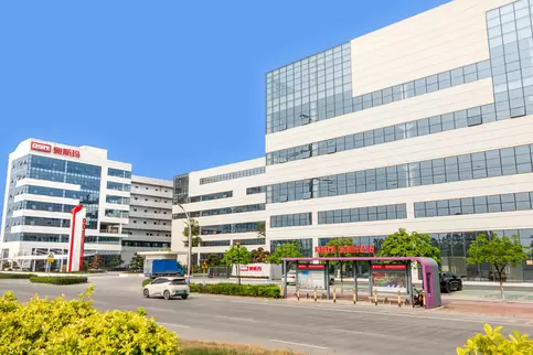 佛山工厂照片相册封面，奥斯玛智能装备生产园区西大门主入口全景图，展示现代化智能工厂建筑外观，融合工业科技与建筑设计美学，体现高端装备制造企业形象，适用于企业官网品牌展示与工业园区宣传场景。